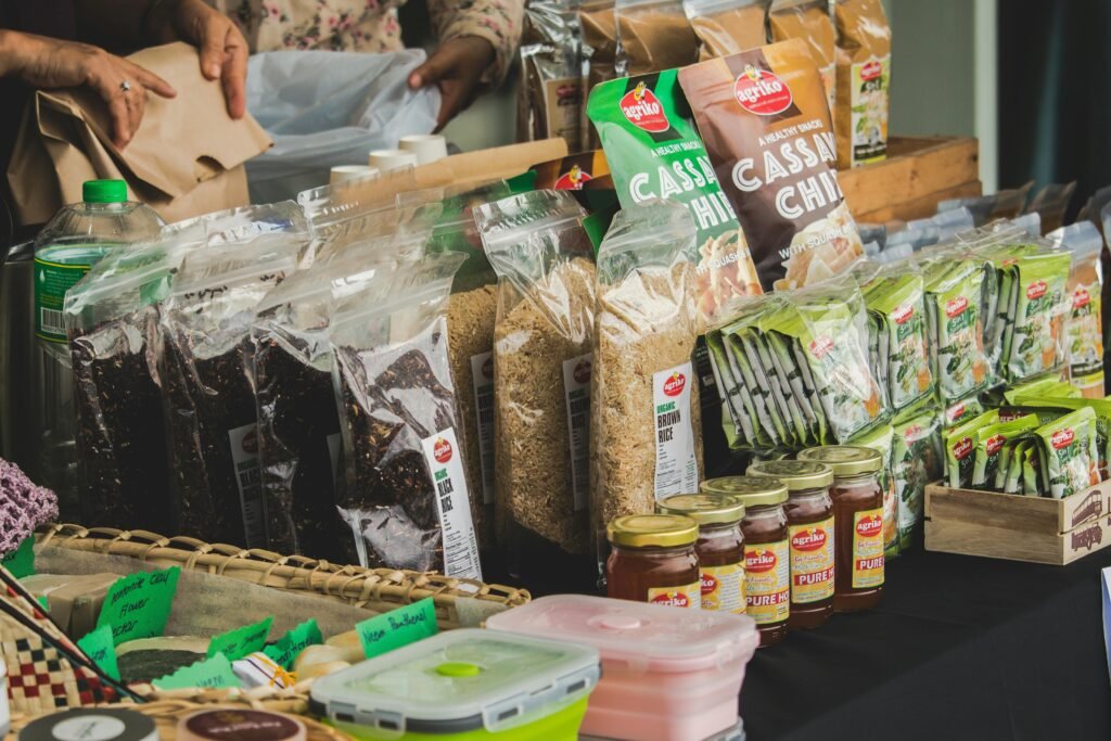 An assortment of packaged foods displayed on a market stall indoors, showcasing variety.